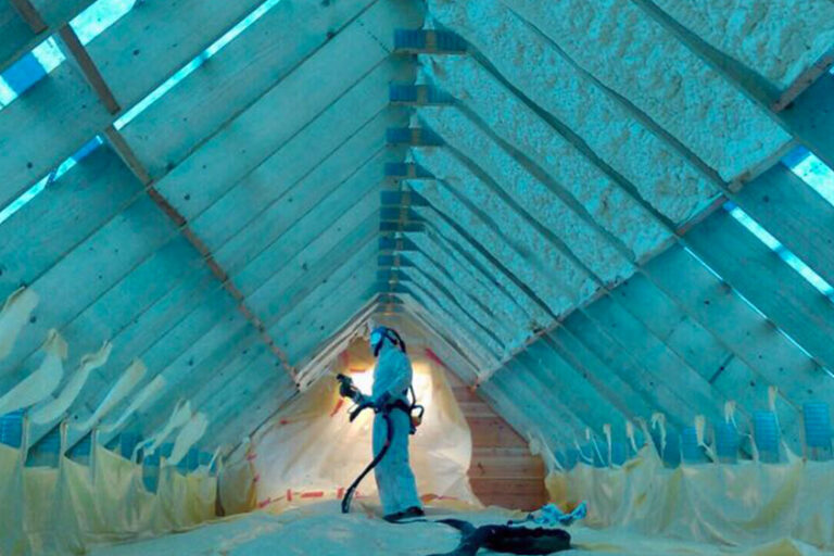 Een werknemer isoleert een groot dak op een industrieel gebouw