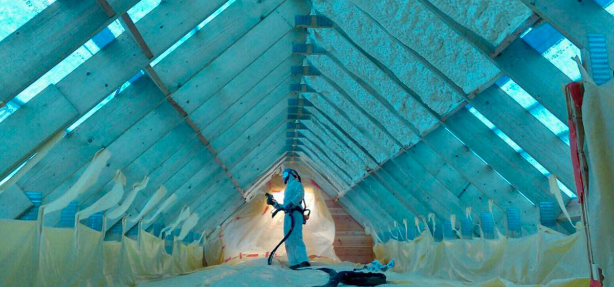 Een werknemer isoleert een groot dak op een industrieel gebouw