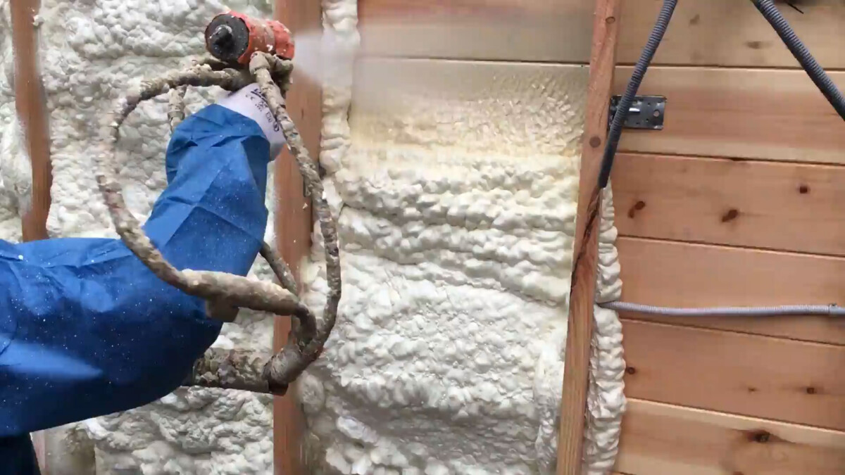 Een expert ISEO PROJECTION die polyurethaanschuim op muren spuit