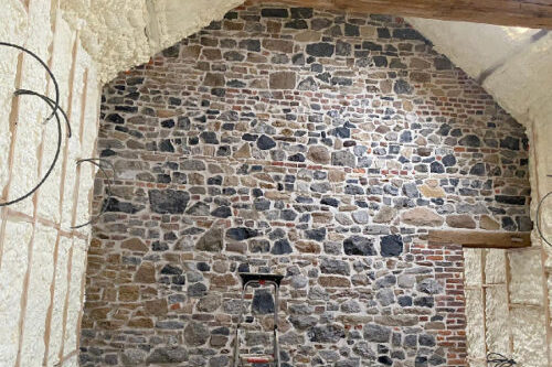 De binnenmuren en het plafond van een kamer isoleren met een mooie stenen muur