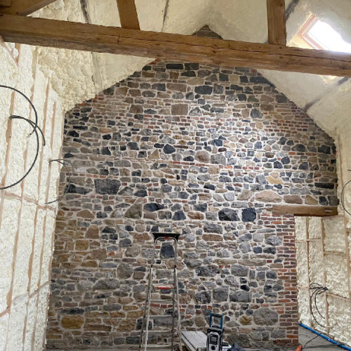 De binnenmuren en het plafond van een kamer isoleren met een mooie stenen muur