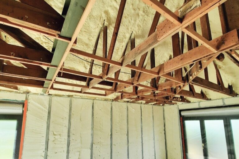 Intérieur d'une maison avec poutres en bois et mousse d'isolation projetée à l'intérieur