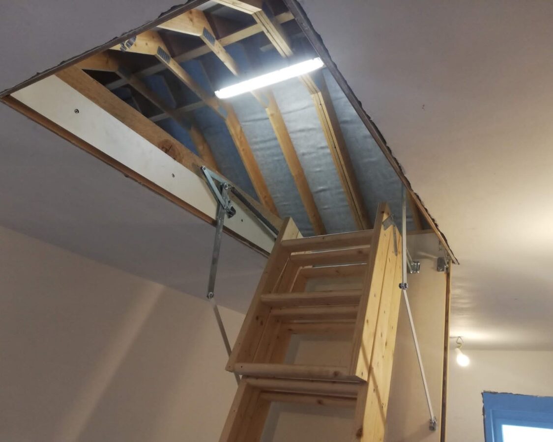 Escalier en bois menant à un chantier d'isolation de grenier par l'intérieur