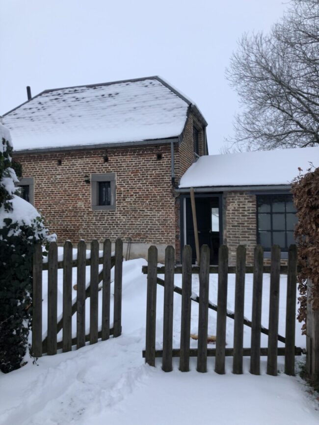 Maison en brique sous la neige à Aische-en-Refail lors d'un chantier de rénovation et d'isolation