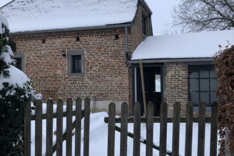 Maison en brique sous la neige à Aische-en-Refail lors d'un chantier de rénovation et d'isolation