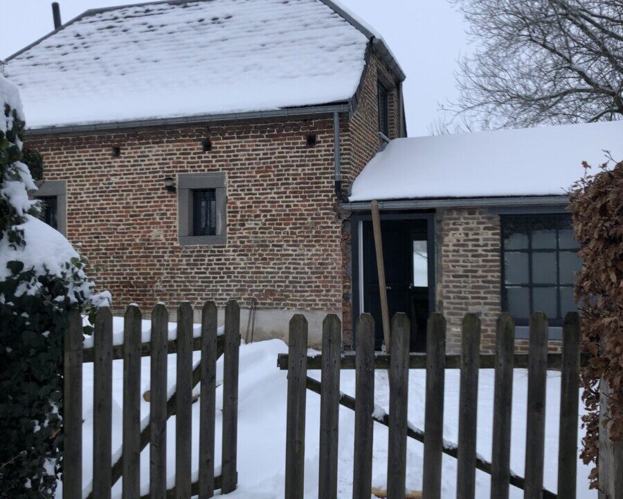 Maison en brique sous la neige à Aische-en-Refail lors d'un chantier de rénovation et d'isolation