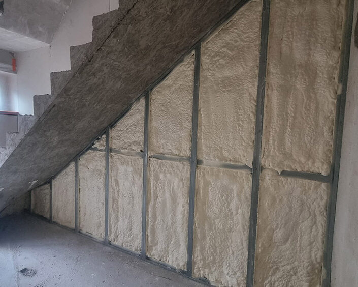 Mousse polyuréthane projetée sur les murs sous un escalier