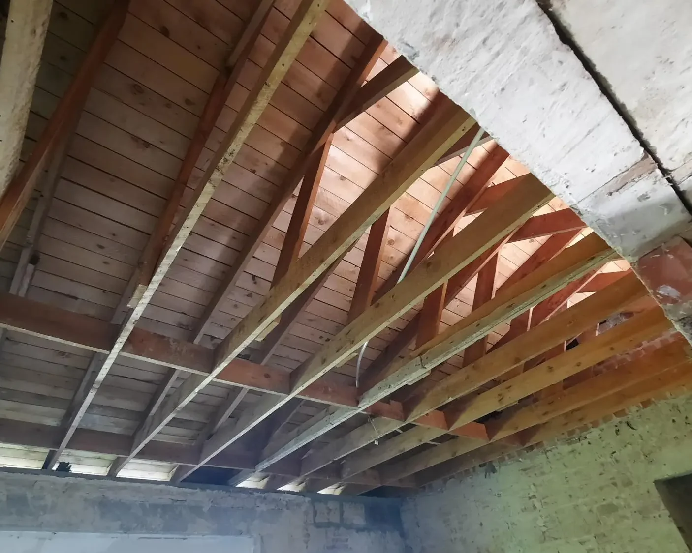 Structure de charpente en bois exposée avant les travaux d'isolation du toit dans une maison en rénovation à Herent.