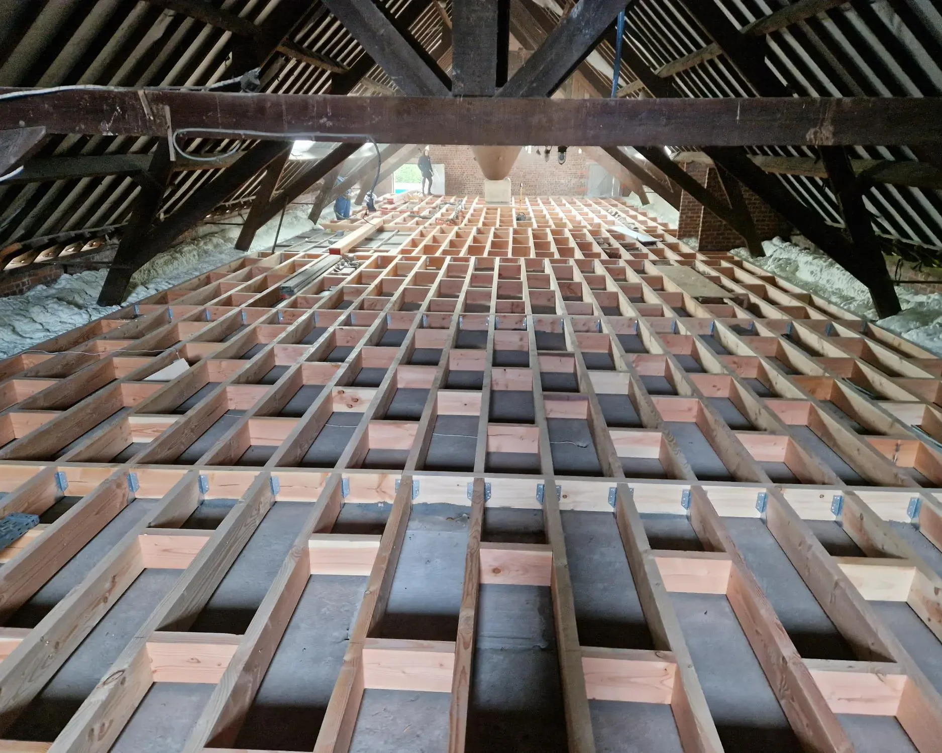 Structure en bois du plancher de grenier à Destelbergen préparée pour l'application de mousse ICYNENE LITE+, garantissant une isolation performante et durable.