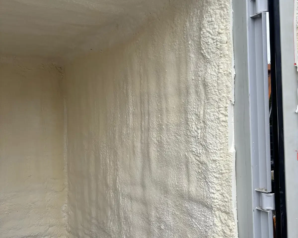 Vue intérieure d’un container maritime isolé avec de la mousse à cellules fermées HFO, mettant en évidence l'isolation des murs et du plafond à Gembloux.
