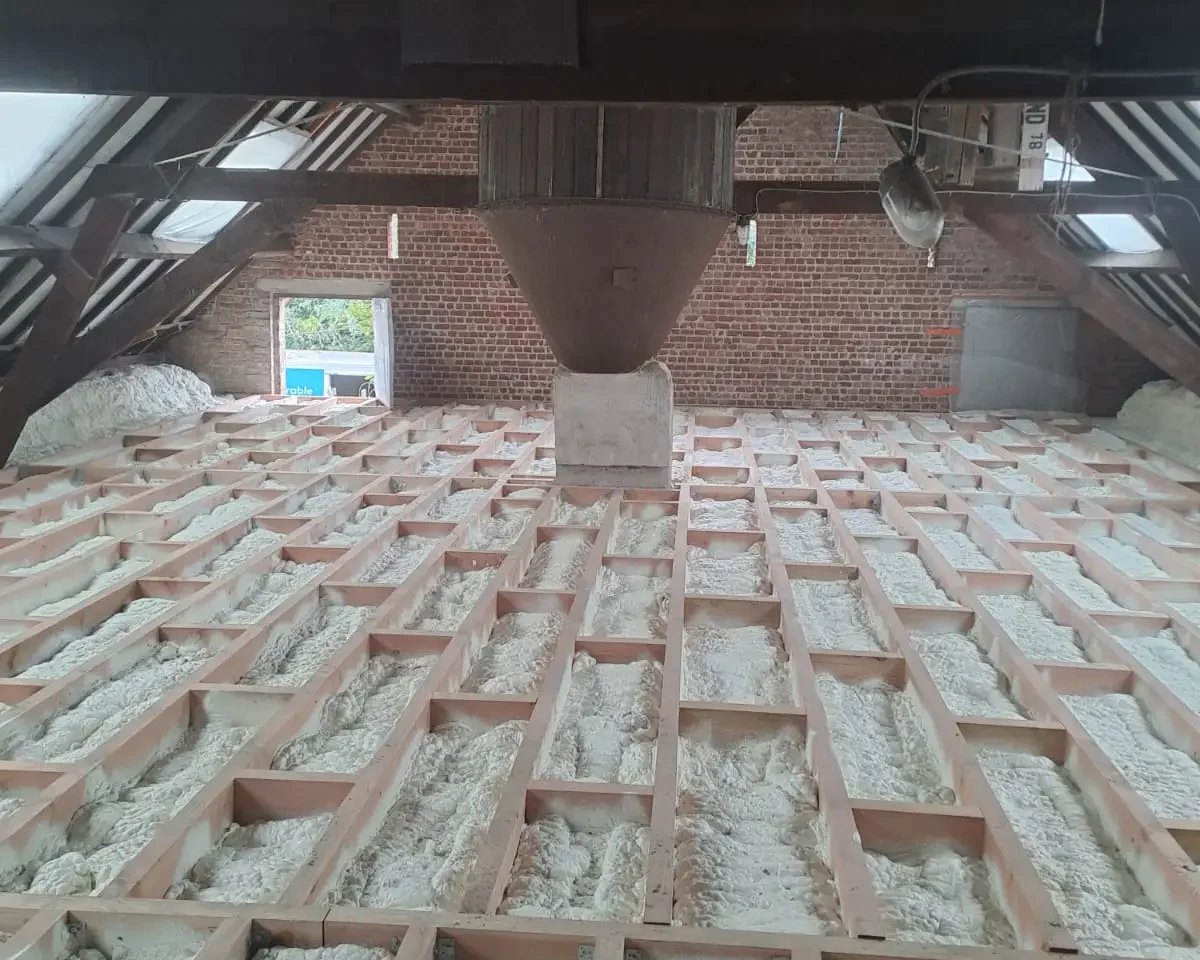 Plancher de grenier à Destelbergen entièrement isolé avec de la mousse ICYNENE LITE+, appliquée entre les poutres pour une isolation thermique et acoustique exceptionnelle.