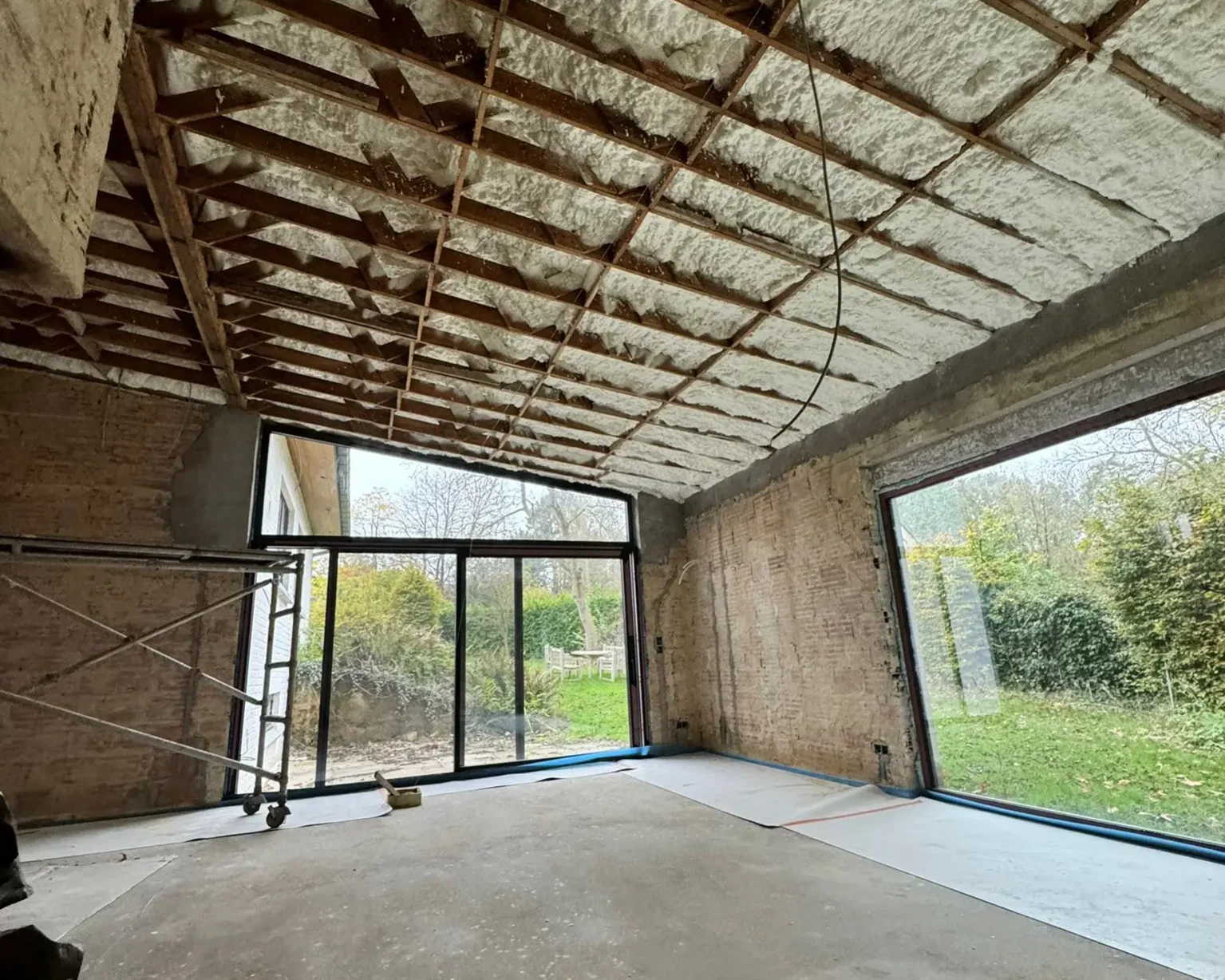 Travaux d'isolation intérieure du toit d'une maison à Herent, réalisés avec de la mousse à cellules ouvertes ICYNENE LITE+ pour une performance thermique et une étanchéité à l'air optimales.