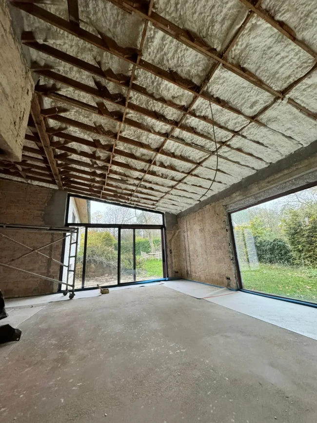 Travaux d'isolation intérieure du toit d'une maison à Herent, réalisés avec de la mousse à cellules ouvertes ICYNENE LITE+ pour une performance thermique et une étanchéité à l'air optimales.