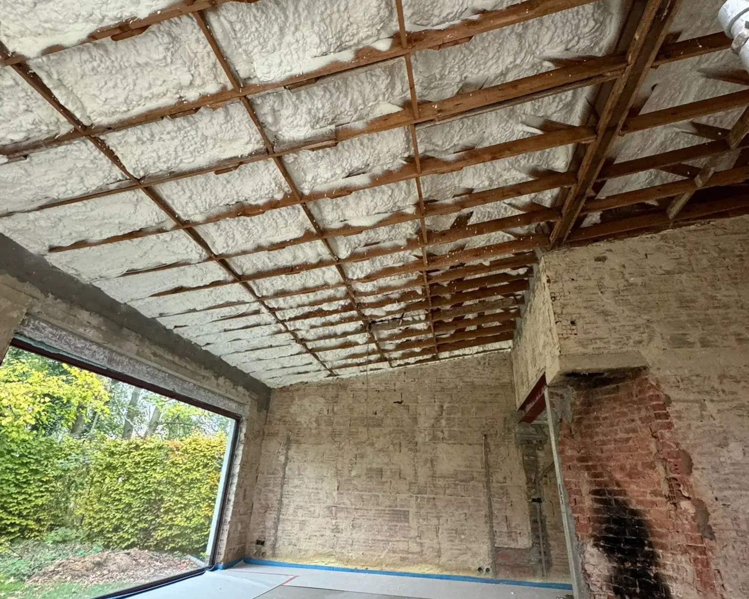 Isolation intérieure du toit d'une maison à Herent, réalisée avec de la mousse à cellules ouvertes ICYNENE LITE+ pour une couverture thermique optimale sur 240 m².