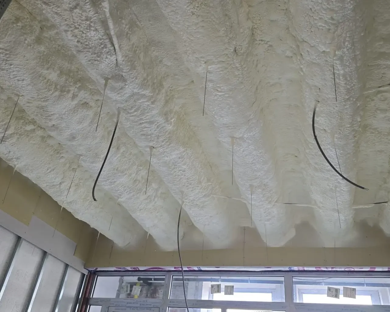 Isolation des coursives de terrasse avec mousse projetée sur une structure métallique à Forest, réalisée par ISEO Projection pour garantir une performance thermique optimale.