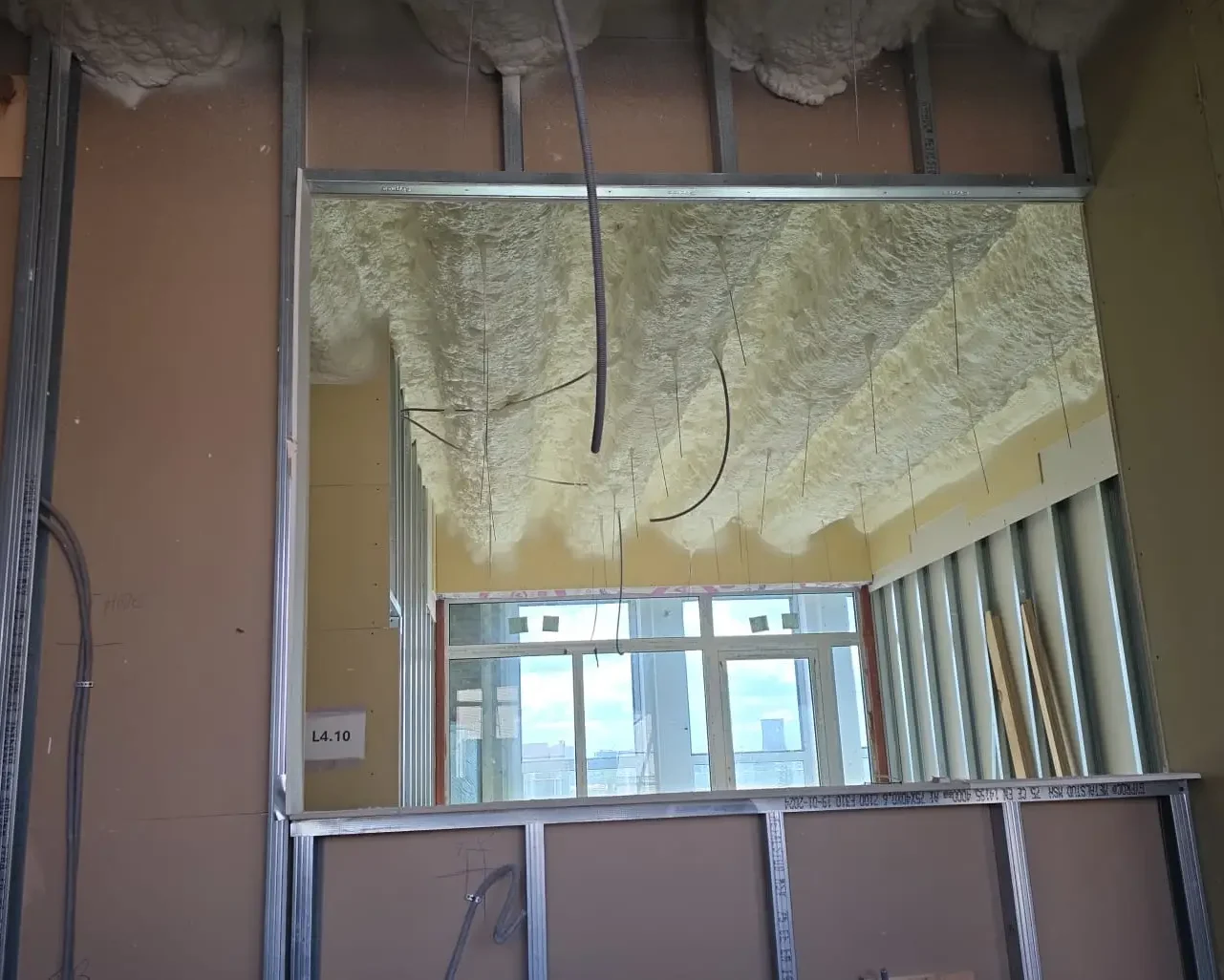 Vue intérieure d’un espace en cours de rénovation avec isolation projetée en mousse sur le plafond, réalisée par ISEO Projection à Forest.