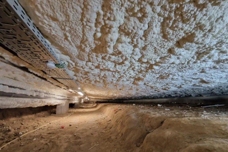 Isolation du vide sanitaire de l'hôtel de ville de Sint-Pieters-Leeuw avec mousse ICYNENE LITE+. Vue du plafond isolé montrant la mousse projetée pour une étanchéité parfaite.