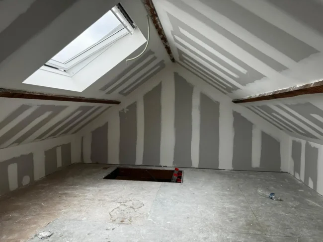 Isolation de toiture et travaux de parachèvement dans une habitation à Seilles avec projection de mousse ICYNENE Lite+ pour une rénovation énergétique complète.