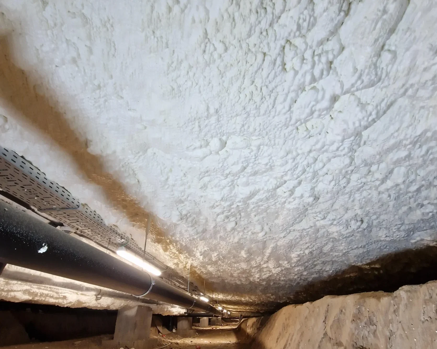 Isolation du plafond du vide sanitaire de Sint-Pieters-Leeuw avec mousse ICYNENE LITE+. Application uniforme garantissant une isolation thermique optimale.