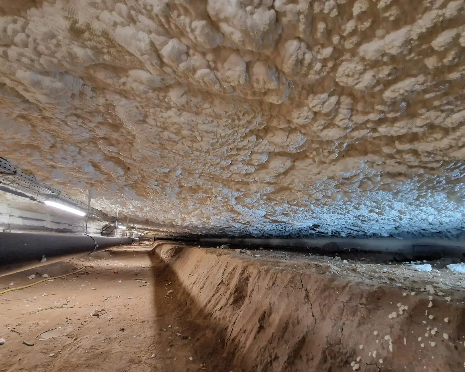Plafond du vide sanitaire non isolé avant intervention à Sint-Pieters-Leeuw, illustrant la surface brute avant l’application de la mousse ICYNENE LITE+.