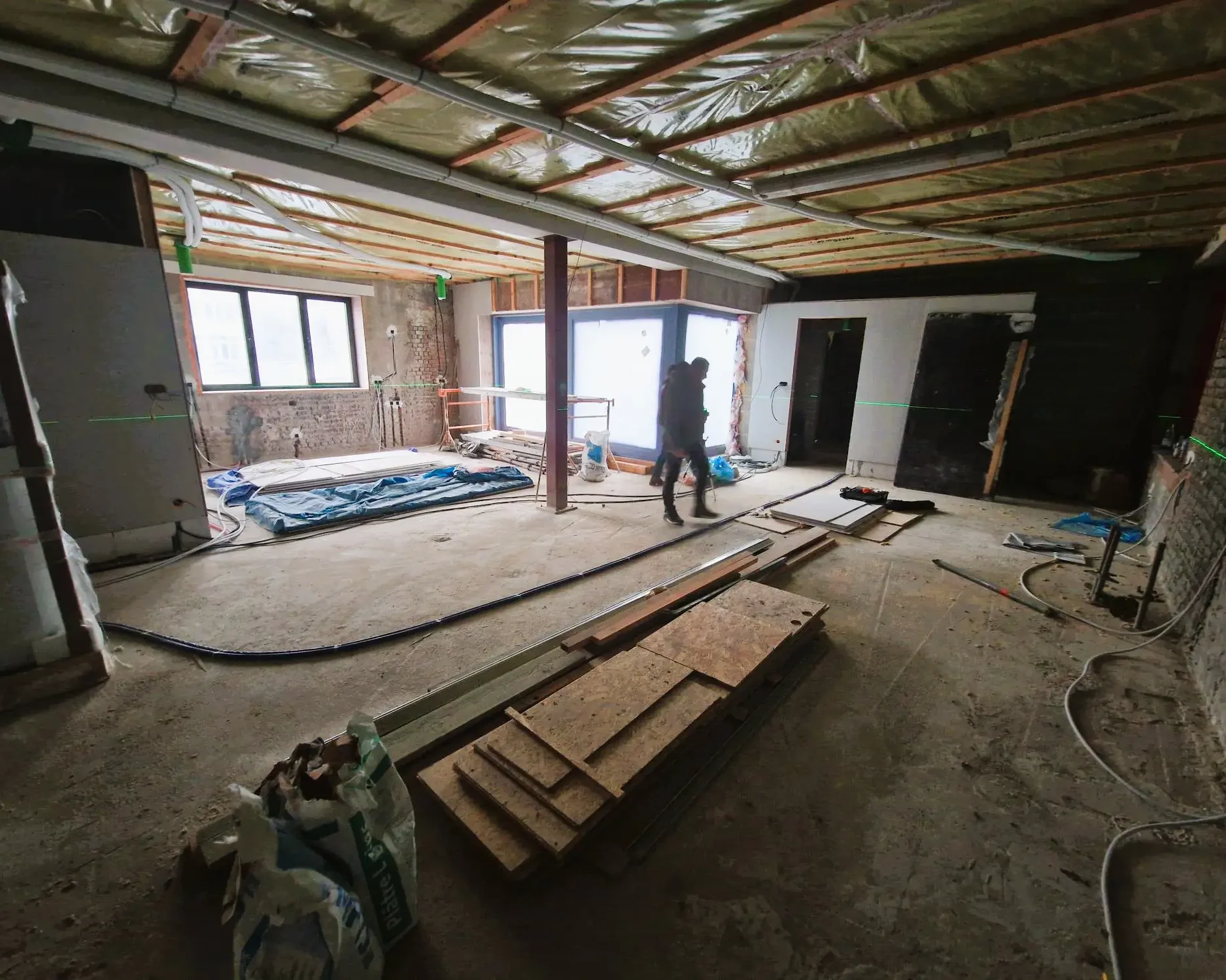 Chantier d’isolation du sol d’un ancien bâtiment industriel à Schaerbeek, avec application de mousse projetée à cellules fermées.