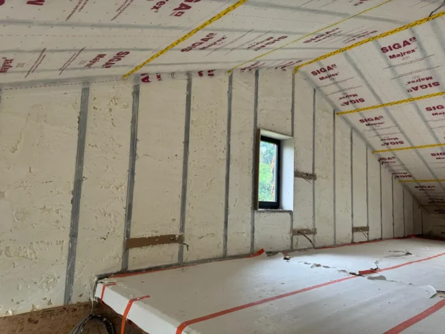 Isolation des murs intérieurs à Jodoigne avec mousse projetée et pare-vapeur pour une performance thermique optimale.