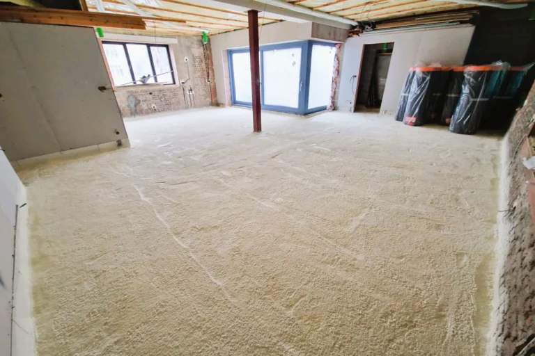 Isolation du sol avec mousse projetée dans un bâtiment en rénovation à Schaerbeek, assurant performance thermique et étanchéité.