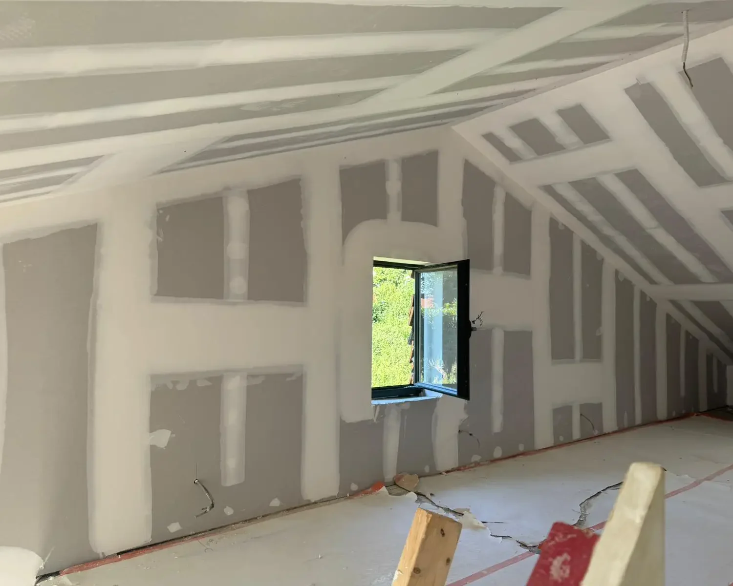 Travaux de parachèvement sur isolant dans un grenier à Jodoigne, avec pose de plaques de plâtre pour une finition impeccable après isolation thermique.