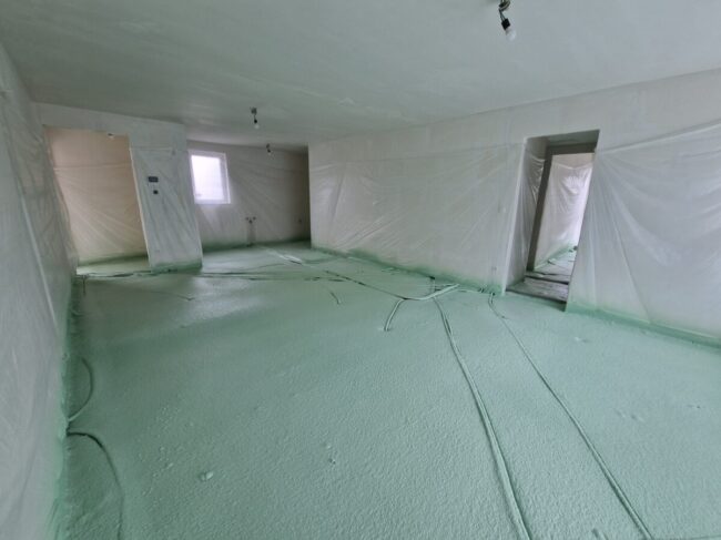 Isolation du sol d'un immeuble résidentiel avec de la mousse projetée