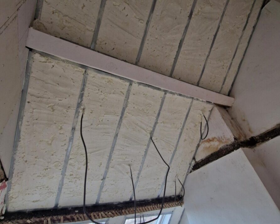 Isolation du plafond avec mousse projetée entre structures bois pour atténuation phonique