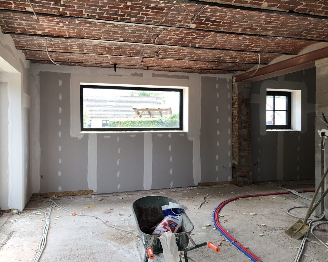 Parachèvement des murs d'une fermette avec un plafond en vou