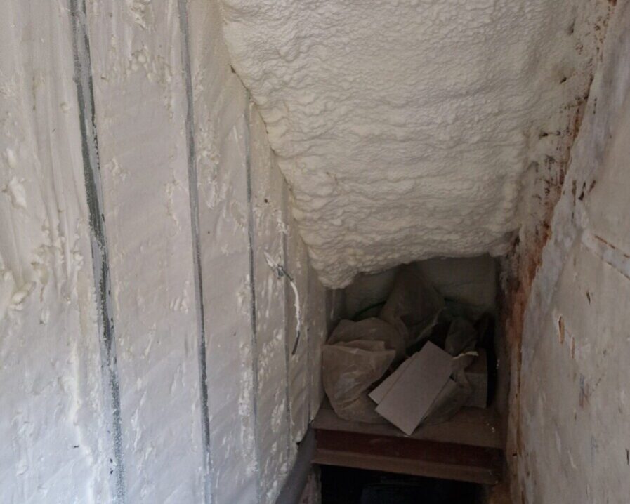 Cage d'escalier d'une cave avec les murs recouverts de mousse projetée