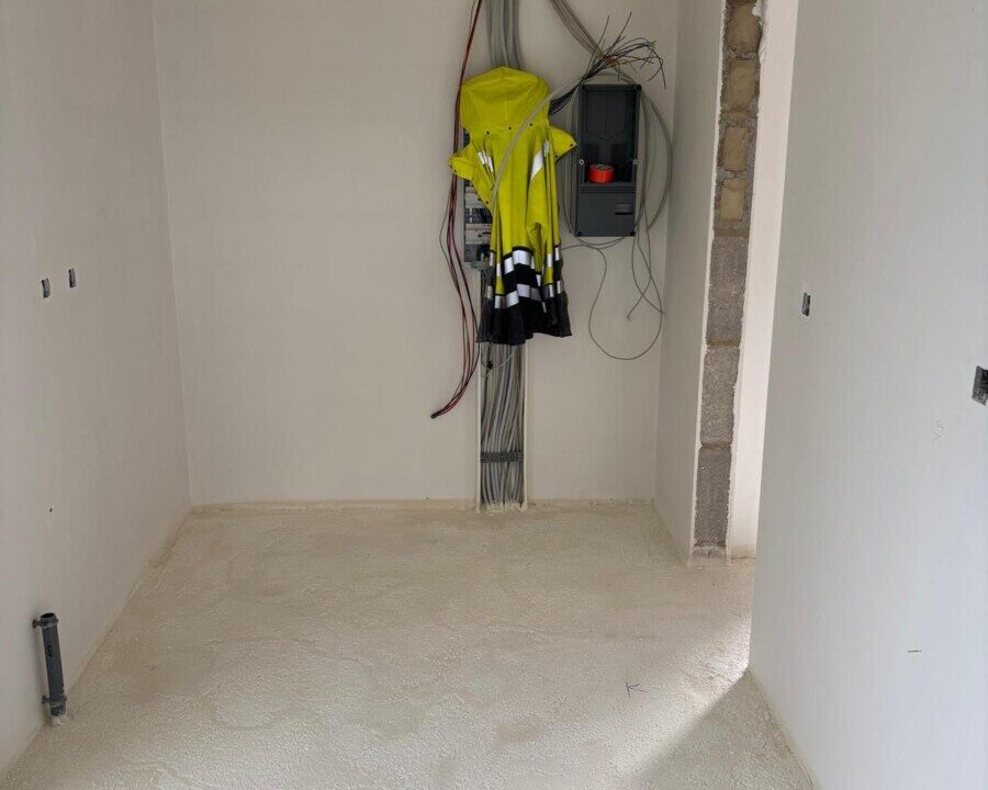 Pièce aux murs blancs dans une nouvelle construction isolée par le sol