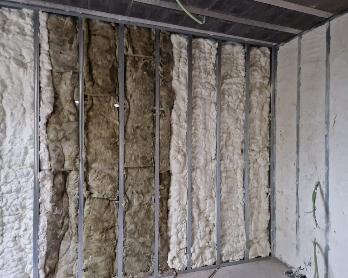 Mur mélangeant un vieil isolant que l'on recouvre avec de la mousse projetée