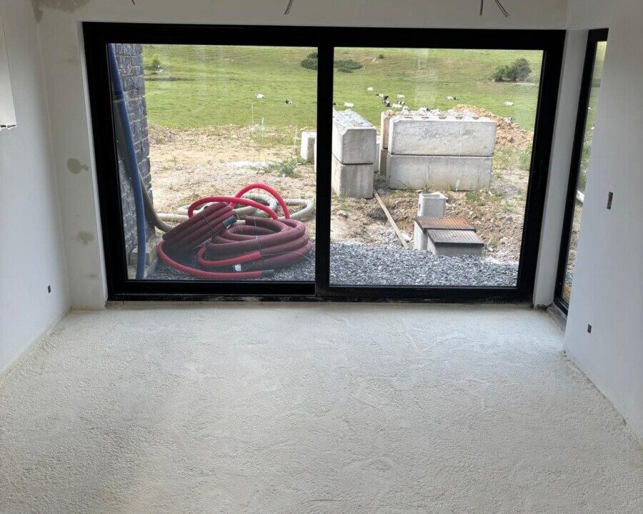 Vue en hauteur d'une baie vitrée et du sol isolé avec de la mousse projetée d'une maison