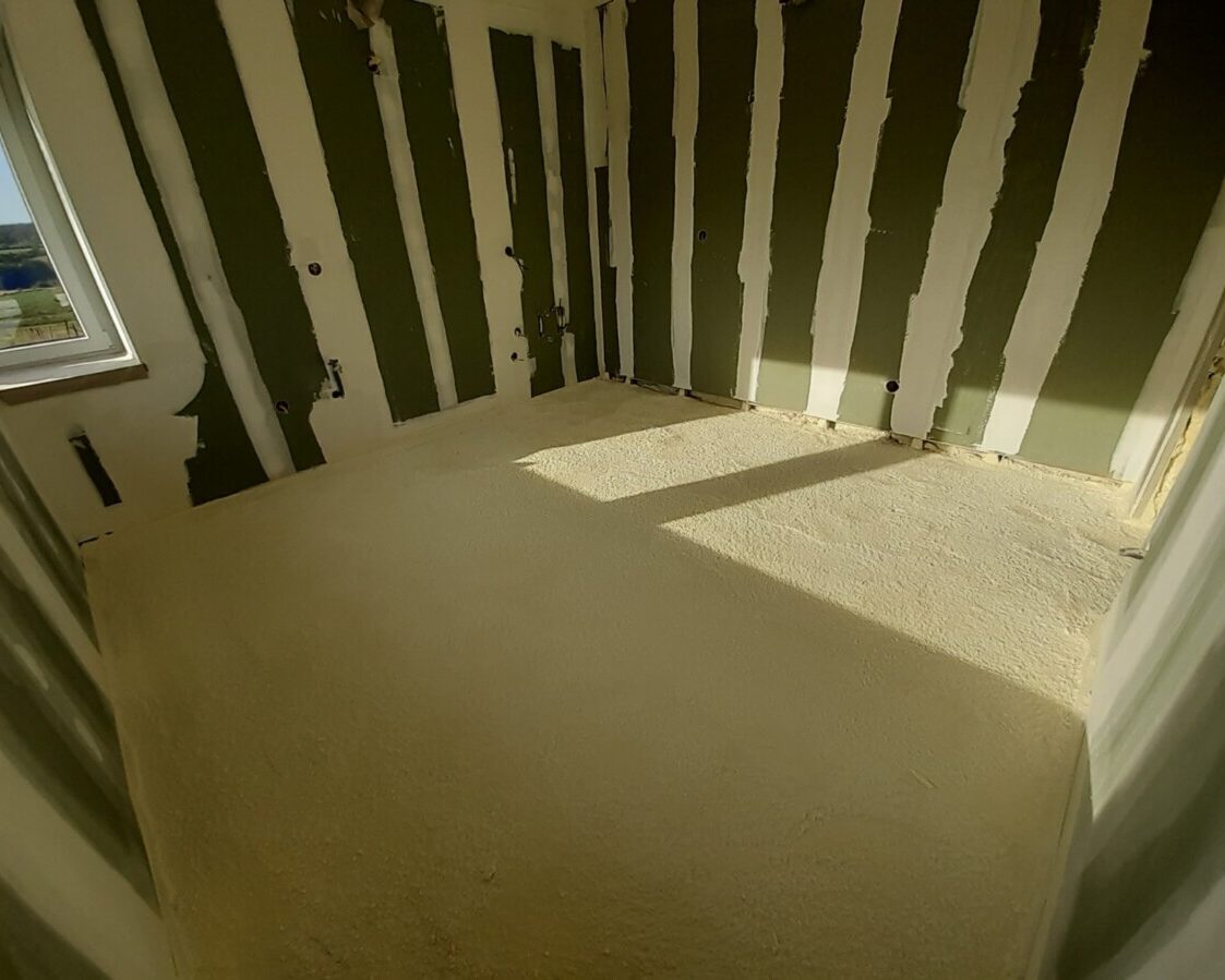 Isolation des sols par mousse projetée d'une maison à Couvin