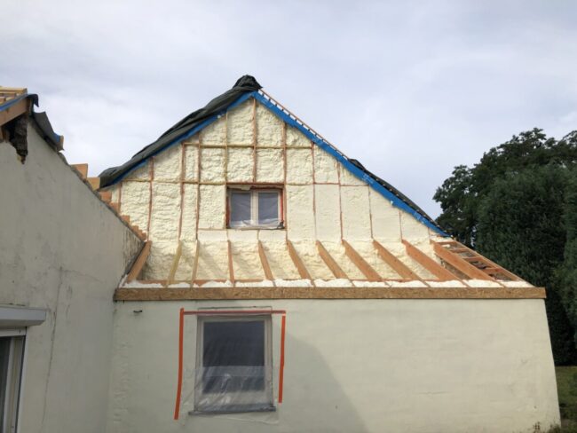 Pignon extérieur d'une maison blanche à Cortil-Wodon que l'on isole avec de la mousse projetée