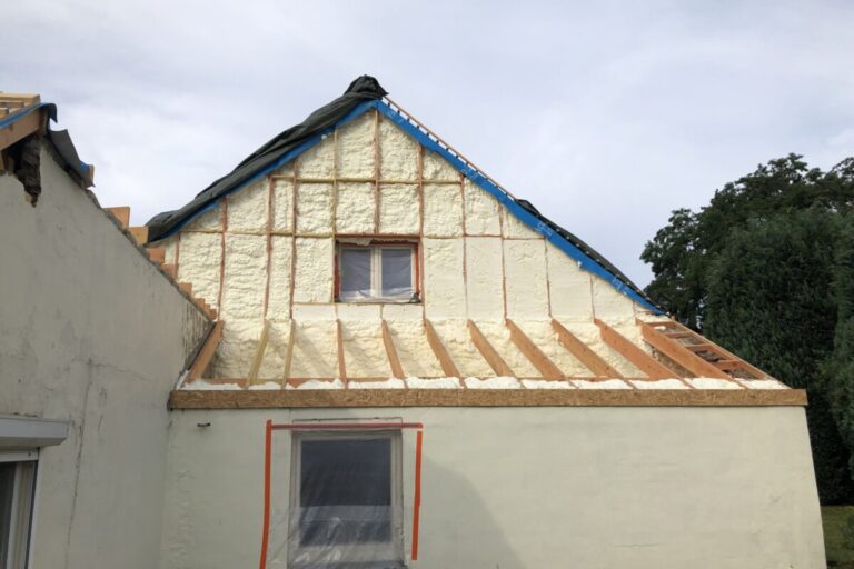 Pignon extérieur d'une maison blanche à Cortil-Wodon que l'on isole avec de la mousse projetée