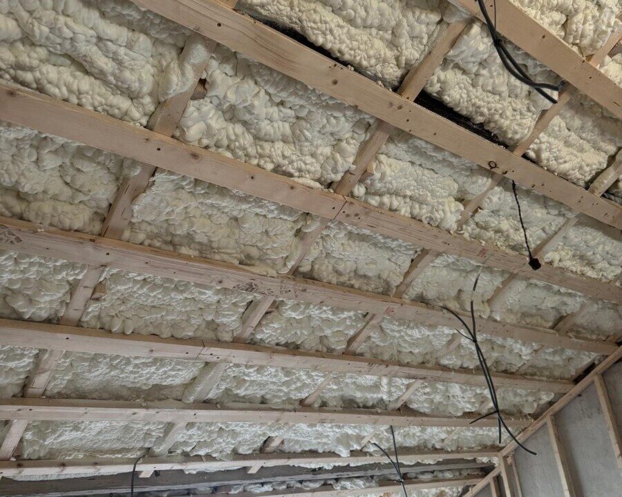 Toiture intérieure avec structure en bois recouverte de mousse isolante projetée