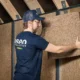 Ouvrier d'ISEO Projection en train de placer de l'isolant en fibre de bois sur le mur d'un grenier