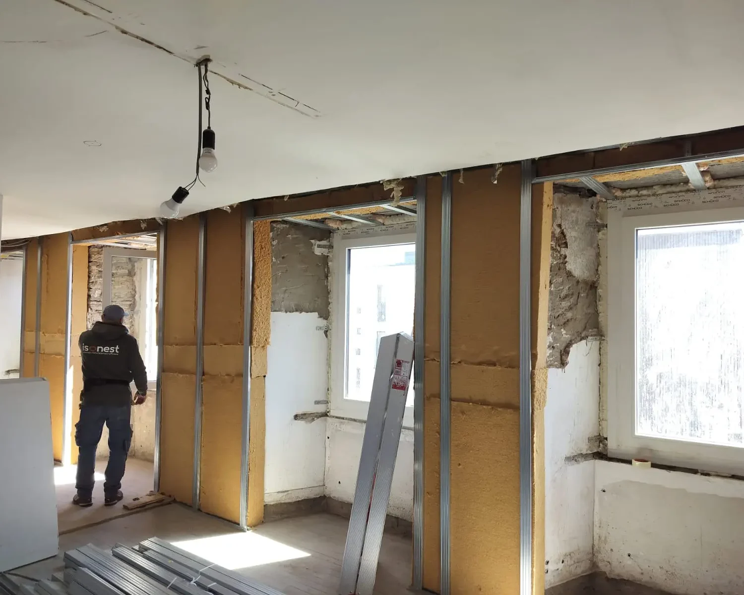 Homme qui travaille sur l'Isolation des murs d'un appartement à Martelange