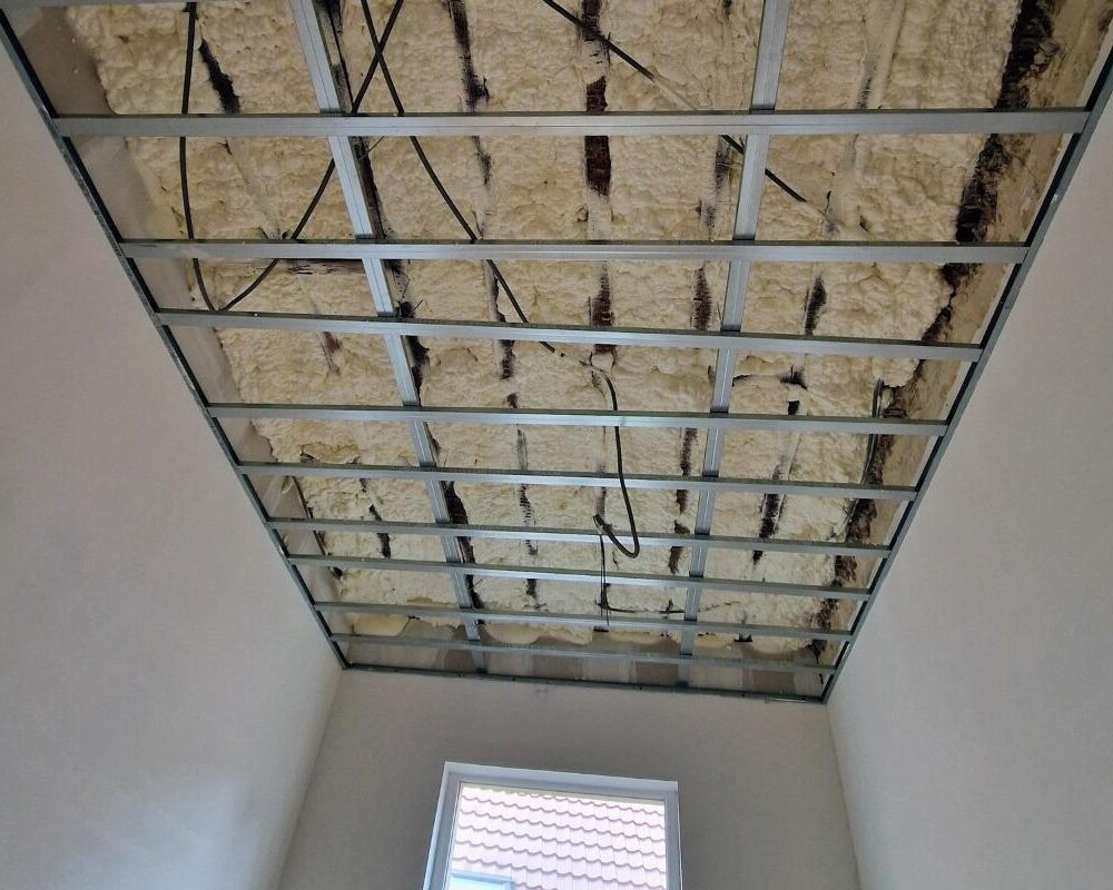 Plafond avec structure métallique recouvert d'isolant projeté