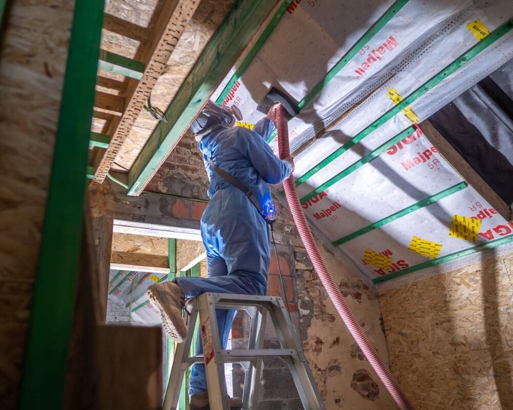 Ouvrier d'ISEO Projection en train d'isoler la toiture d'une maison avec de la laine de bois
