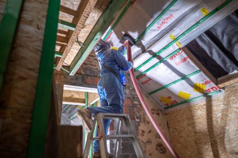 Ouvrier d'ISEO Projection en train d'isoler la toiture d'une maison avec de la laine de bois