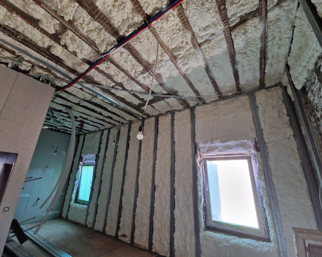 Isolation des murs et du plafond en mousse polyuréthane H2O à cellules ouvertes dans une maison en rénovation à Zaventem : ossature métallique et finitions intérieures en cours de pose.
