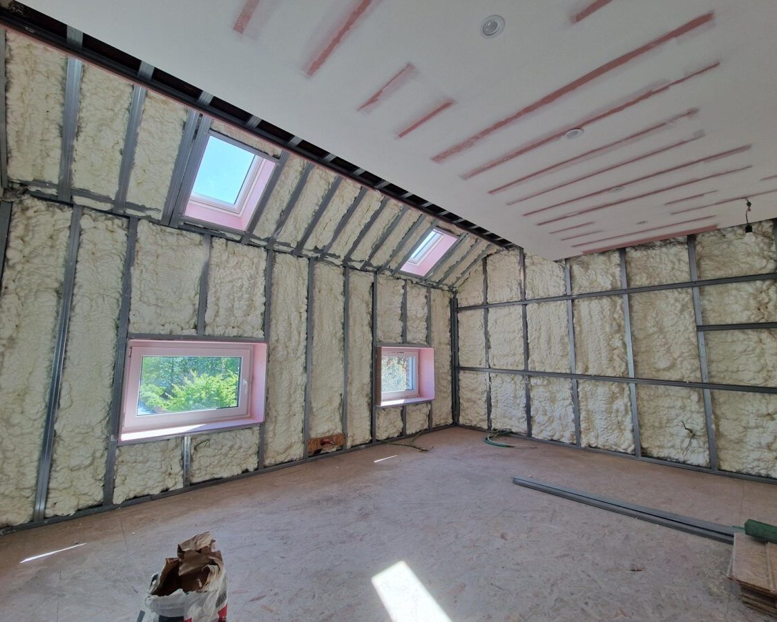 Isolation de toiture en mousse polyuréthane H2O (17 cm) sur les rampants d'une maison unifamiliale à Zaventem, avec fenêtres de toit et plafond partiellement parachevé.