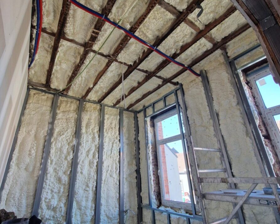 Chantier d'isolation de murs et de toiture à Zaventem : projection de mousse H2O à cellules ouvertes sur l'enveloppe thermique complète d'une maison unifamiliale en rénovation.