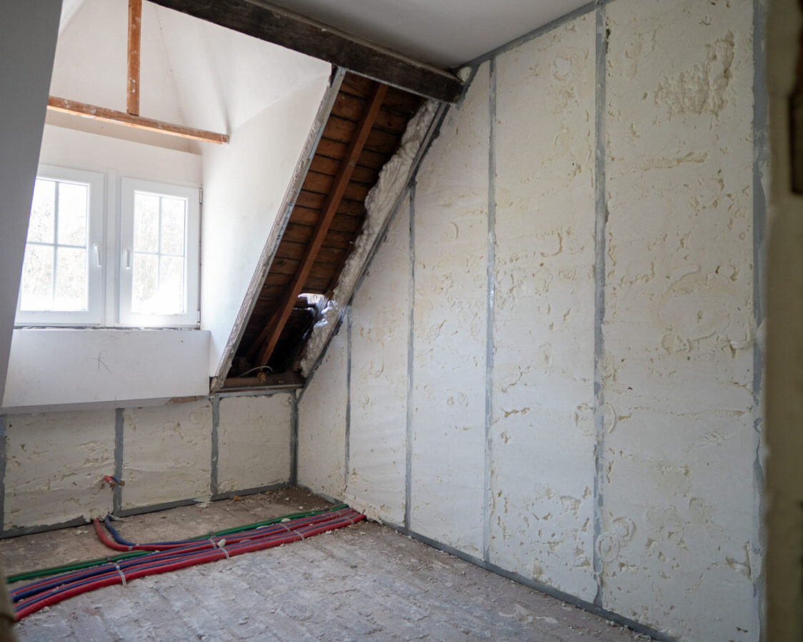 Murs intérieurs isolés par mousse polyuréthane projetée dans une pièce sous toiture, garantissant une isolation continue sans pont thermique.