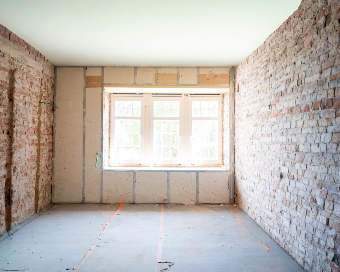 Chambre en rénovation dont les murs ont été isolés par projection de mousse polyuréthane à cellules ouvertes sur une maçonnerie ancienne en briques.