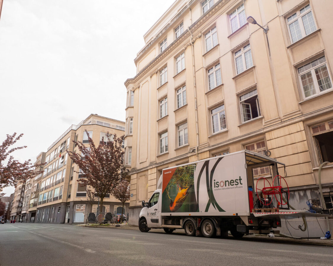 Camion d’insufflation stationné devant un immeuble à Etterbeek pour réaliser l’isolation intérieure des murs par ouate de cellulose.